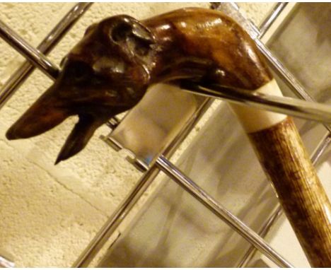 WALKING STICK. Hand carved wooden greyhound headed walking stick L:120 cm