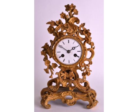 A LATE 19TH CENTURY ORMOLU MANTEL CLOCK with white enamel dial, of elaborate rococo form. 11.5ins high.
