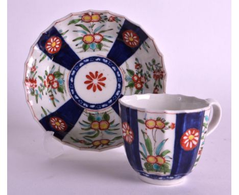 AN 18TH CENTURY WORCESTER FLUTED COFFEE CUP AND SAUCER painted with Oriental flowers between blue panels. 