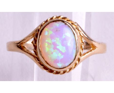 A 9CT GOLD AND SYNTHETIC OPAL RING. 