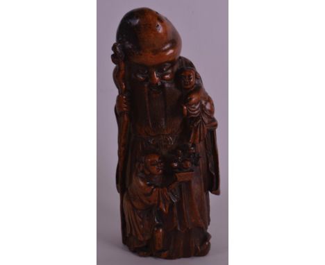 A 17TH/18TH CENTURY CHINESE CARVED BAMBOO FIGURE OF SAGE Late Kangxi, modelled holding two children within his arms, and a st