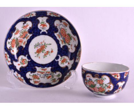 AN 18TH CENTURY WORCESTER BLUE SCALE CUP AND SAUCER painted in the kakiemon palette with flowers. 