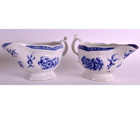 A PAIR OF 18TH CENTURY WORCESTER UNCOMMON SAUCEBOATS painted in blue with flowers. 8.25ins wide.