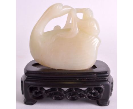 AN EARLY 20TH CENTURY CHINESE CARVED GREEN JADE DUCK modelled as a lotus flower within its mouth, upon a later hardwood stand