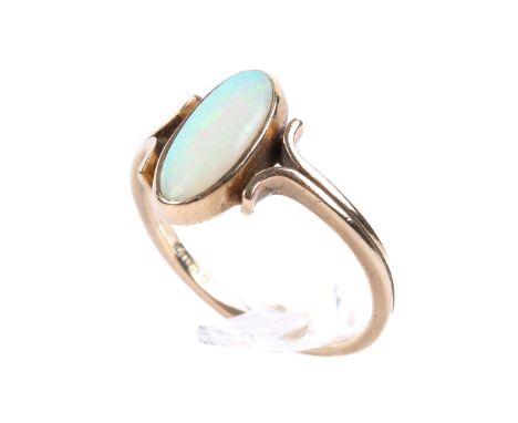 A 9ct gold and opal ring. The slender oval opal flanked by scrolls. With hallmarks, size M, weight 2g. 