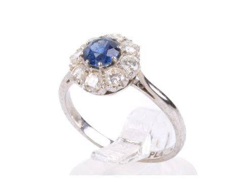 A diamond and sapphire cluster ring. With eight small times around the vivid blue stone, the shank marked 18ct PLA. Size O/P,