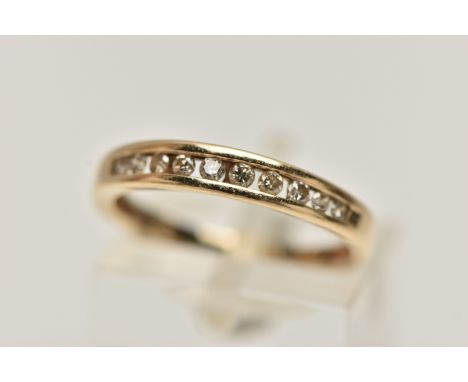 A YELLOW METAL DIAMOND HALF ETERNITY RING, designed as a row of ten channel set, round brilliant cut diamonds, estimated tota