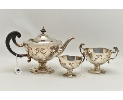 A GEORGE V WALKER &amp; HALL SILVER THREE PIECE PEDESTAL TEA SERVICE, of shaped circular form with cut card decoration, leaf 