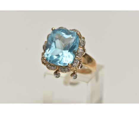 A 9CT GOLD TOPAZ AND DIAMOND DRESS RING, centring on a large cushion cut blue topaz, measuring approximately length 14.0mm x 