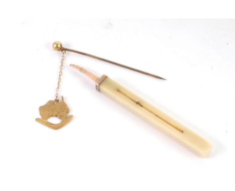 9ct  GOLD STICK PIN, with fine chain suspending a silhouette of Australia over a boomerang and a bone and gold coloured metal