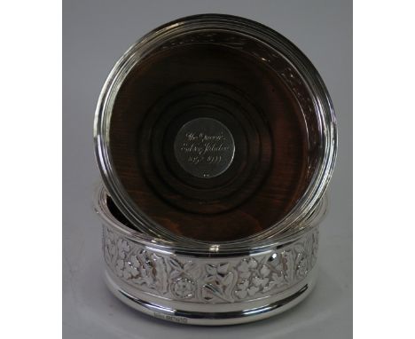 A PAIR OF SILVER DECANTER COASTERS COMMEMORATING 'THE QUEENS SILVER JUBILEE 1952-1977', the sides repousse with flowers repre