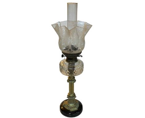 Brass column oil lamp with clear glass reservoir and etched shade.