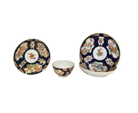 A group of 18th century Worcester porcelain in scale blue ground, floral painted comprising a tea bowl and saucer and two oth