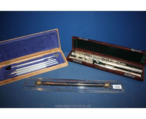 A flute in a box and two scientific instruments.