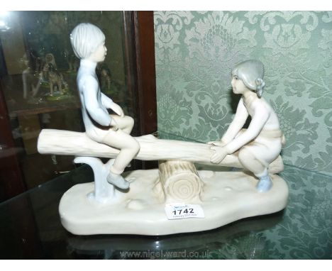 A figure of girl and boy on log seesaw, possibly Nao.