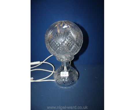 An electric glass table lamp with globe shade.