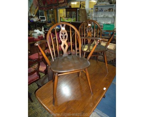 A pair of Ercol fleur-de-lys splat Elbow Chairs