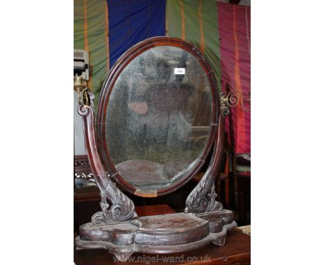 A Victorian Mahogany swing Mirror with shaped base having trinket compartment, the oval mirror flanked by swinging brass cand