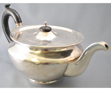 A round silver teapot, of very plain form, with a slightly domed cover over a flat top and a baluster body, by Weir &amp; Son