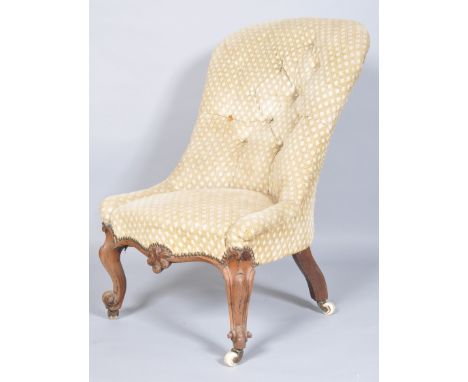 A plain button backed nursing chair on a mahogany framed base with shaped carved decoration, raised on cabriole legs with cer