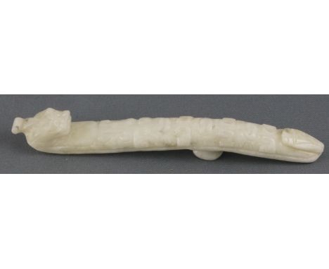 A carved Chinese pale celadon jade belt hook, the s-formed body carved with a dragon's head hook above scrolls, the underside