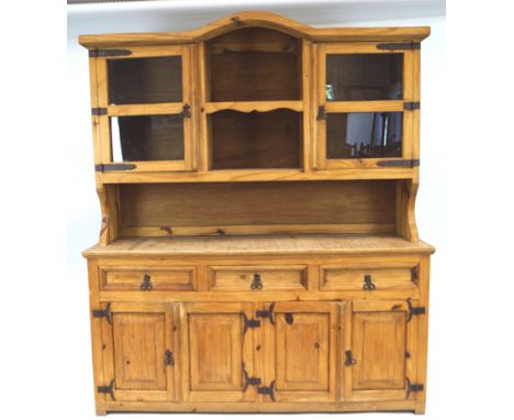 A Continental pine dresser, the raised back with two glazed doors flanking an open shelf above three drawers above four cupbo