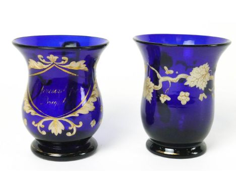 A 19th century blue glass mug painted in enamels and gilt, with loop handle and pontil mark, 11cm high, together with another