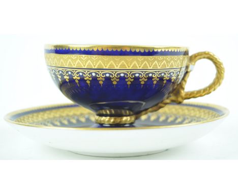 A 19th century porcelain cabinet cup and saucer with tooled gilt bands and white enamel jewelling on a blue ground, marked wi