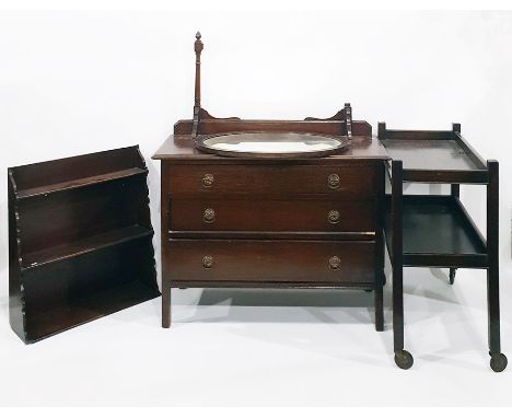 Stained oak chest of three long drawers, a two-tier oak tea trolley, a three-shelf wall rack and an oval wall mirror with bev