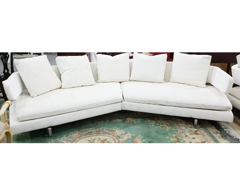 Contemporary angled sofa with seven loose squab cushions, on stainless steel supports 