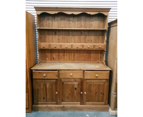 Reproduction pine dresser, the two shelf open plate rack with six small drawers, three frieze drawers below and three fielded