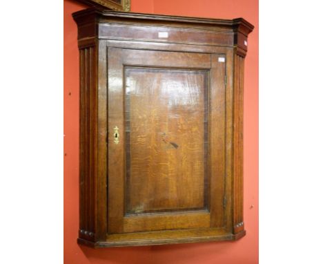 A LATE GEORGIAN PERIOD INLAID OAK HANGING CORNER CUPBOARD, with central panel door, flanked with fluted pilasters, 37" (94m) 