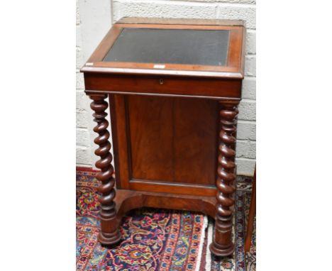 AN EARLY VICTORIAN MAHOGANY SLOPE-TOP DAVENPORT, the interior fitted with drawers, raised on a pedestal with panel door enclo