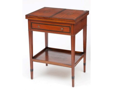 AN EBONY BANDED SATINWOOD FOLDOUT CARD TABLE OR PATIENTS TABLE, the double foldout top inlaid with shelves, above a frieze dr