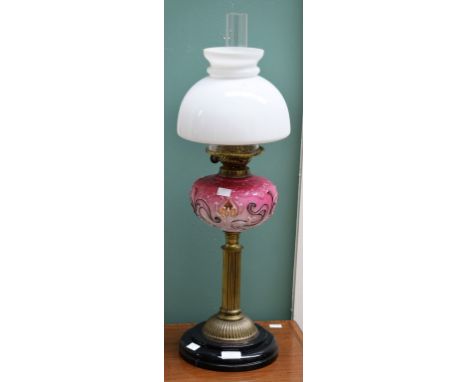 A LATE VICTORIAN BRASS AND MOULDED PINK GLASS OIL LAMP, with milk glass shade, on turned and stepped black ceramic base, 27" 