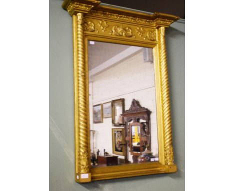 A GILT OVERMANTLE MIRROR, the rectangular plate in a relief moulded fluted frame, each upper corner with a lion mask in relie