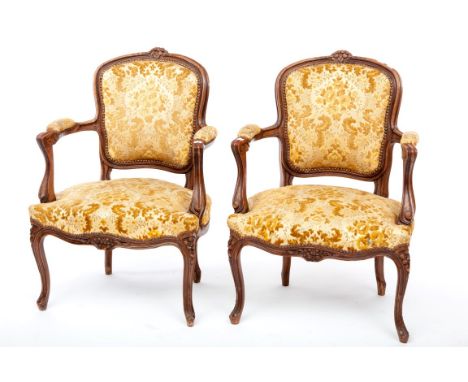 A FINE PAIR OF LOUIS XV STYLE GILT ARMCHAIRS, each cartouche-shaped back crested with flowers, above a padded panel and padde