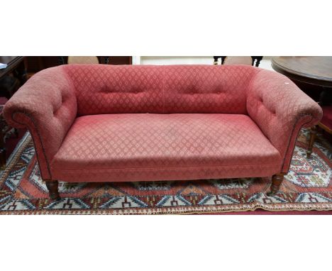 A LATE VICTORIAN MAHOGANY CHESTERFIELD SETTEE, with button back and sides, and sprung cushion seat, raised on four turned leg