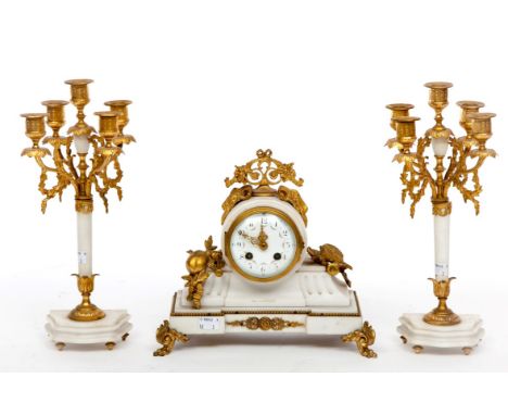 A LATE 19TH CENTURY THREE-PIECE FRENCH WHITE MARBLE AND GILT METAL MANTEL CLOCK GARNITURE, comprising a clock with floral cre
