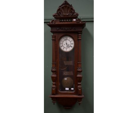 A WALNUT-CASED VIENNA WALL CLOCK, with shell crest above a circular two-stage enamel dial, with Roman numerals, inside an arc