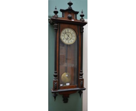 A VICTORIAN WALNUT AND EBONISED VIENNA TYPE WALL CLOCK, the arched pediment with a centre lion mask and three urns, above a t