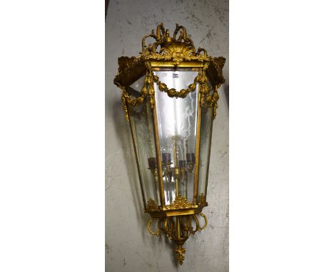 A LARGE HEAVY GILT BRASS LANTERN, of tapering hexagonal form, with leaf-cast scroll corona above a rim with shell and leaf sp