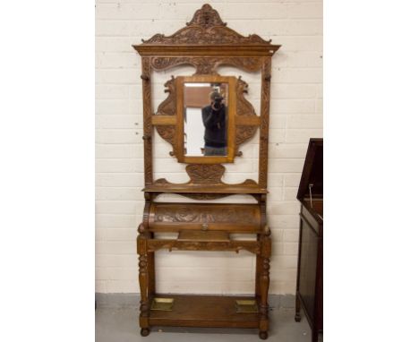 AN ATTRACTIVE CARVED OAK HALL STAND, early 20th century, the shaped pediment with grotesque mask and scrolling foliage above 