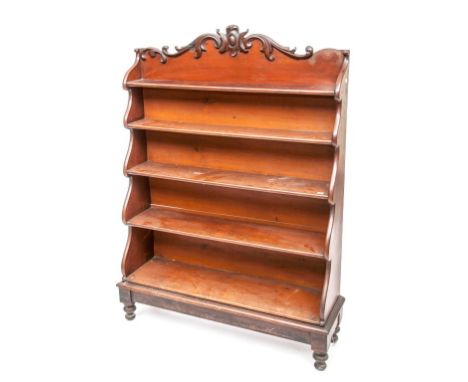 A GOOD VICTORIAN MAHOGANY FIVE SHELF WATERFALL BOOKCASE, with cartouche crest issuing leaf scrolls, over graduating shelves a