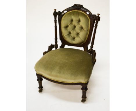 A VICTORIAN WALNUT NURSING CHAIR, with oval button back and bow-fronted seat, raised on turned and fluted front legs. (1) 