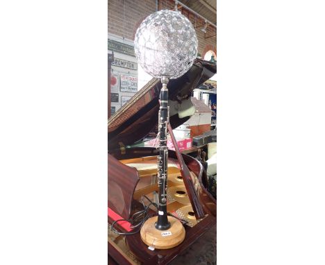 A CONTEMPORARY TABLE LAMP MADE FROM A VINTAGE CLARINET, mounted on a turned elm base with a wire-work shade, 87cm high (overa
