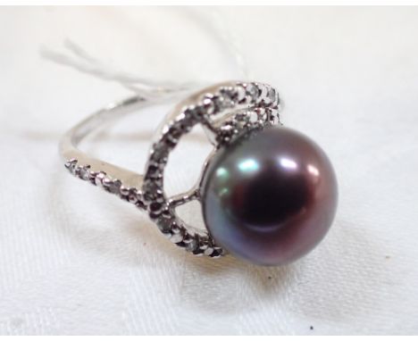 A BLACK SIMULATED PEARL DRESS RING, the pearl with green / mauve hues, on a silver shank, ring size M