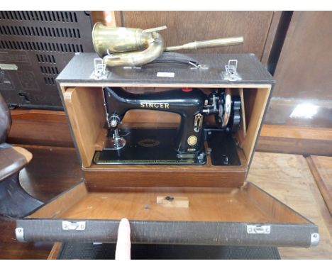 A VINTAGE SINGER SEWING MACHINE with rubber Singer mat and a brass car horn