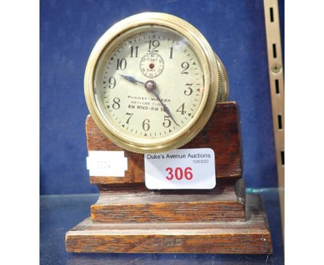 AN EDWARDIAN BRASS CASED, 'KEYLESS' CLOCK, 7cm dia. on an oak stand