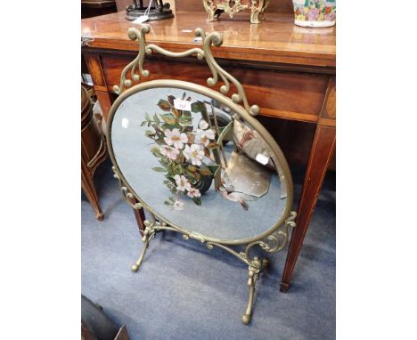 A VICTORIAN CIRCULAR BRASS FRAMED MIRRORED FIRE SCREEN painted with a bird and Briar Roses on scrolled feet, 53cm wide